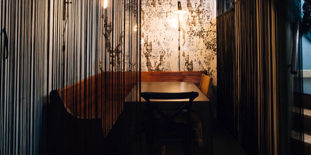 A candlelit booth behind string curtains at Hopfields
